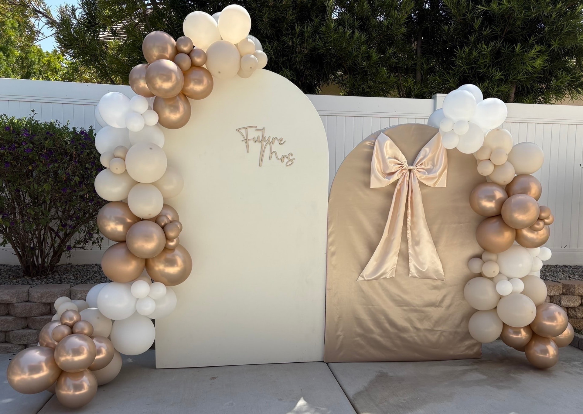 Ivory and champagne balloon garlands framing two arched backdrops